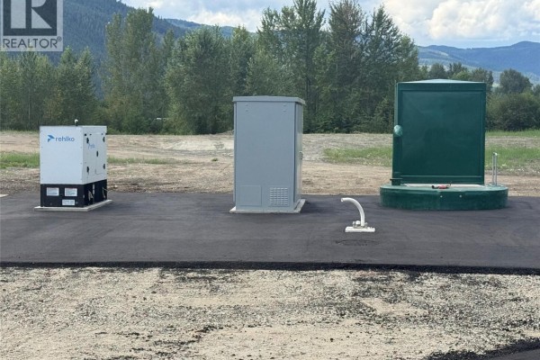 Construction equipment lined up on dirt road with mountains in the distance. - 1837 Shuswap Avenue Lot# 6, Lumby