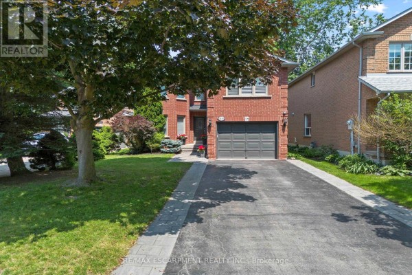 Driveway leading to the front of a red brick house with a garage. - 1839 Fellen Place, Mississauga