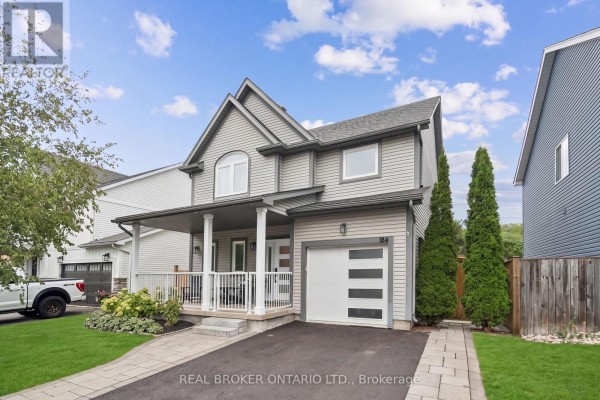 Front exterior of a two-story grey house with a covered porch and garage on a sunny day. - 184 Dunbar Street, Guelph/eramosa
