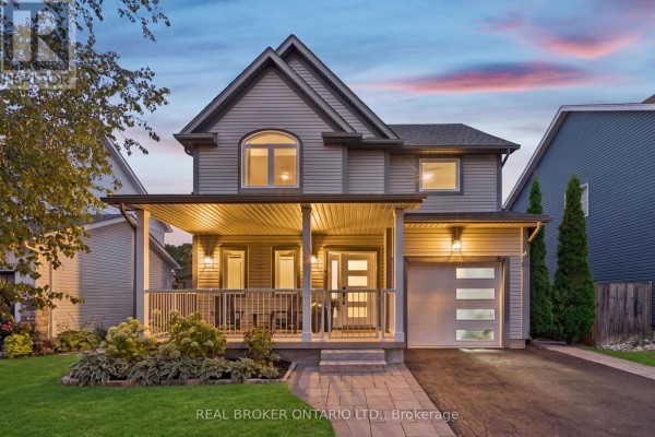 Front exterior of a two-story grey house at dusk with a covered porch and garage. - 184 Dunbar Street, Guelph/eramosa