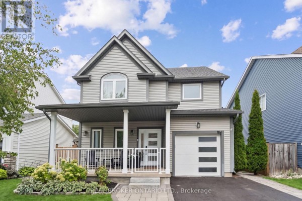Front exterior of a two-story grey house with a covered porch and garage on a sunny day. - 184 Dunbar Street, Guelph/eramosa