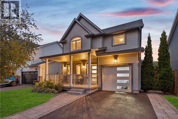 Dusk exterior view of a grey siding two-story house with a covered porch and garage. - 184 Dunbar Street, Rockwood