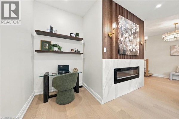 A compact office nook with a glass desk, chair, laptop, and floating shelves. - 184 Torresdale Avenue, North York