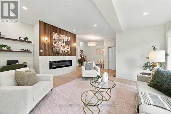 Living room with fireplace, wood accent wall, and modern furniture. - 184 Torresdale Avenue, Toronto