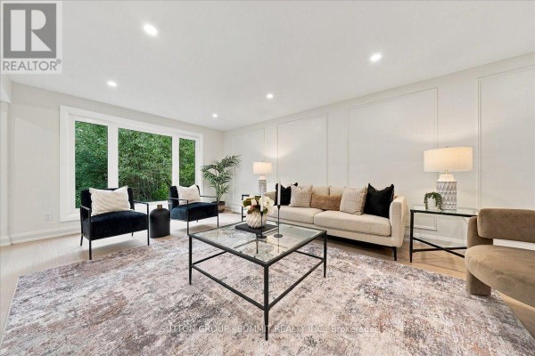 Living room with large windows, several seating areas, and a glass coffee table. - 184 Torresdale Avenue, Toronto
