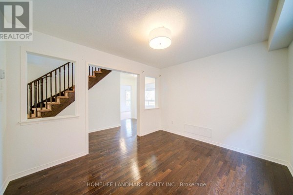 Curved staircase with wooden railing leading to upper floor, laundry room visible - 1842 Esterbrook Drive, Oshawa