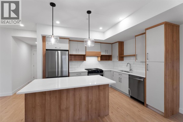 Modern kitchen with light grey cabinets, white subway tile backsplash, and an island. - 1844 Qu'appelle Boulevard Unit# 203, Kamloops