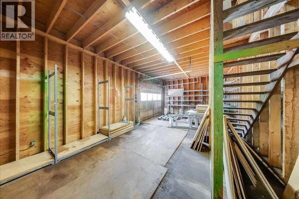 Unfinished commercial space with wood-paneled walls, concrete floor, and exposed ceiling joists. - 1846 First Street, Fruitvale