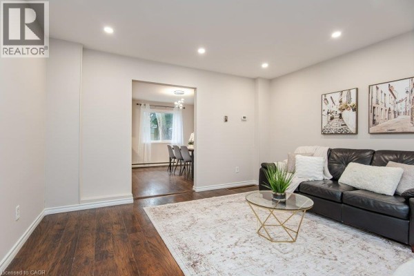 View from living room into a dining room with a table and chairs, and a window. - 185 Cedarvale Crescent Unit# A, Waterloo