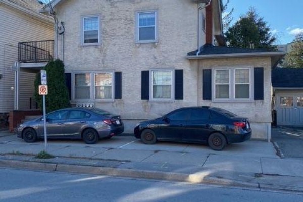 Exterior of a multi-family house with two parked cars on the street. - 185 James Street, St  Catharines