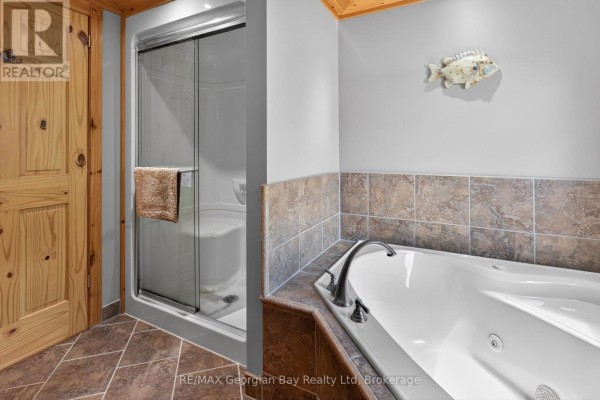 Bathroom with a large corner bathtub and a separate glass shower stall. - 185 Picnic Island Road, Georgian Bay
