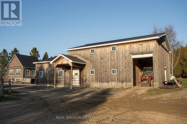 Outdoor shelter and wooden fence in a grassy field under a bright sky. - 1850 Ridge Road W, Champlain