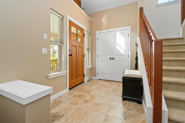 Interior foyer with tile flooring, double closet doors, and carpeted stairs. - 1852 Ravenwood Trail, Cultus Lake South, Lindell Beach