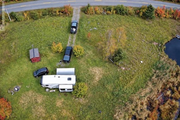 Aerial view showing gravel driveway, RV, red shed, and pond. - 1852 River John Road, River John