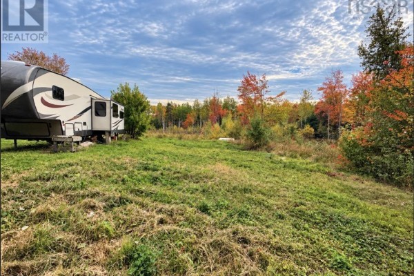 View of RV parked on grassy land with colorful trees in background. - 1852 River John Road, River John