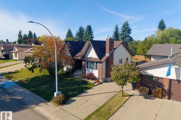 Aerial view of a suburban house with a red brick and white stucco exterior, a pitched roof, and a concrete driveway. - 18528 98 Av Nw, Edmonton