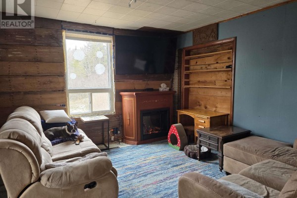 Laundry room with a stacked washer and dryer, utility sink, and doors leading outside. - 18540 Country Harbour  Hwy 316 Highway, Country Harbour
