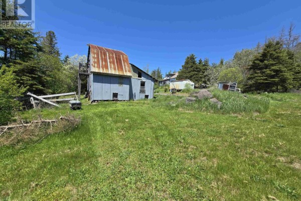White mailbox with house number 18540 next to a paved road with a rural landscape beyond. - 18540 Country Harbour  Hwy 316 Highway, Country Harbour