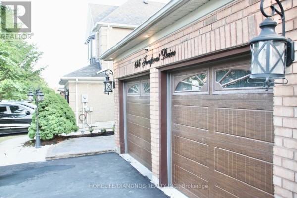 Detail of two adjacent garage doors on a brick house with arched window panes. - 186 Fernforest Drive, Brampton