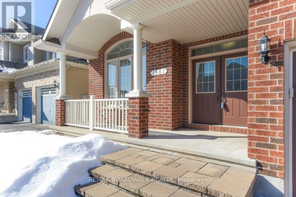 Brick house exterior with covered porch, double entry doors, arched window - 1861 Mickelberry Crescent, Ottawa