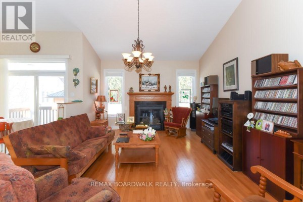 Living room with fireplace, hardwood floors, vaulted ceiling, sliding door - 1861 Mickelberry Crescent, Ottawa