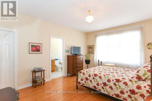 Bedroom with hardwood floors and adjoining bathroom - 1861 Mickelberry Crescent, Ottawa