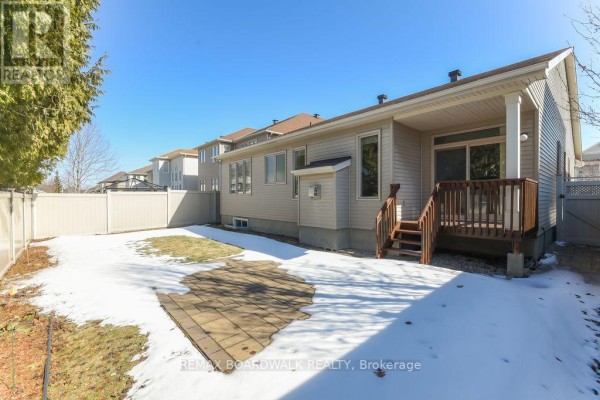 Backyard with wooden deck, sliding glass door, patio pavers, and fence - 1861 Mickelberry Crescent, Ottawa