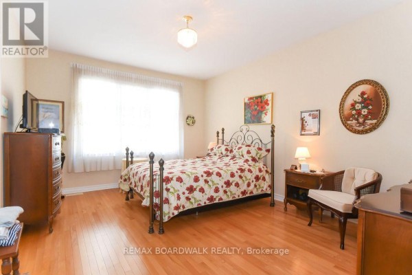 Bedroom with hardwood floors, large window, and metal frame bed - 1861 Mickelberry Crescent, Ottawa