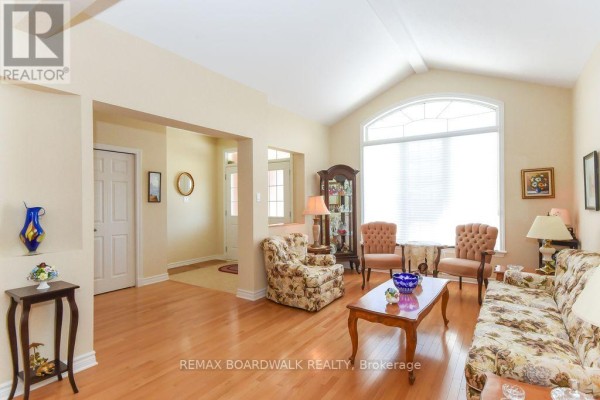 Living room with hardwood floors, vaulted ceiling, arched window - 1861 Mickelberry Crescent Ottawa