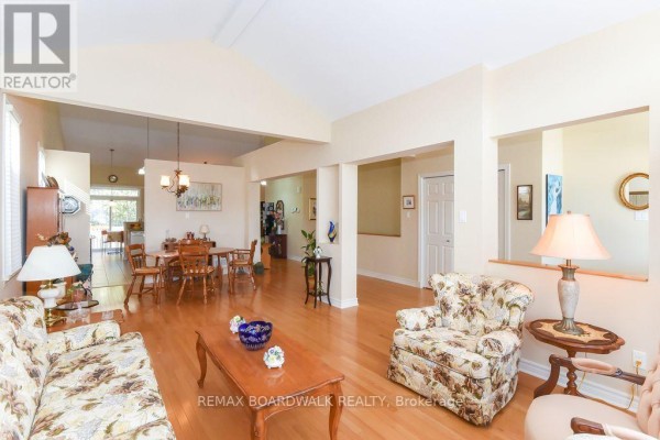 Living room with vaulted ceiling, hardwood floors, open to dining room - 1861 Mickelberry Crescent Ottawa