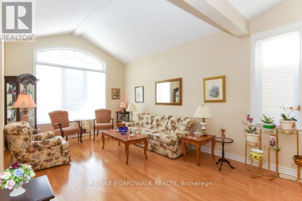 Living room with vaulted ceiling, hardwood floors, large arched window - 1861 Mickelberry Crescent, Ottawa