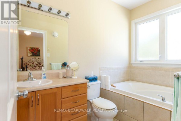 Single vanity, drop-in bathtub, and toilet in a bathroom - 1861 Mickelberry Crescent, Ottawa