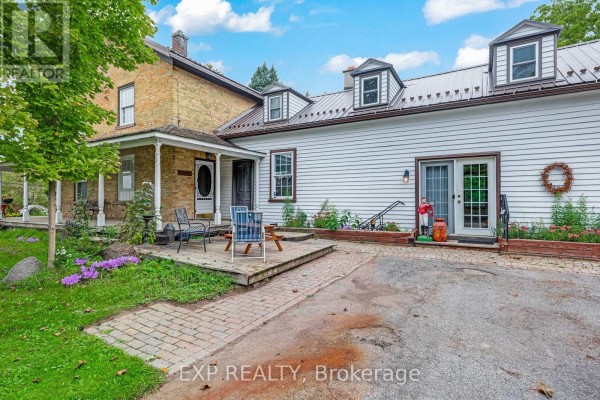 Close-up of the house exterior showing a patio, sliding glass door, and steps leading to a driveway. - 18611 Leslie Street, East Gwillimbury