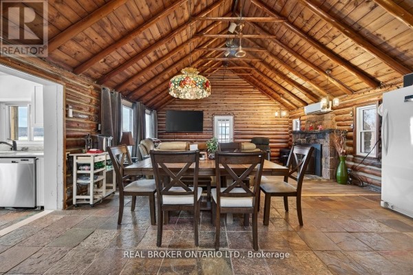 Dining area with wooden ceiling, views of the outdoors, and adjacent kitchen. - 1866 Tay Bay Road, Severn