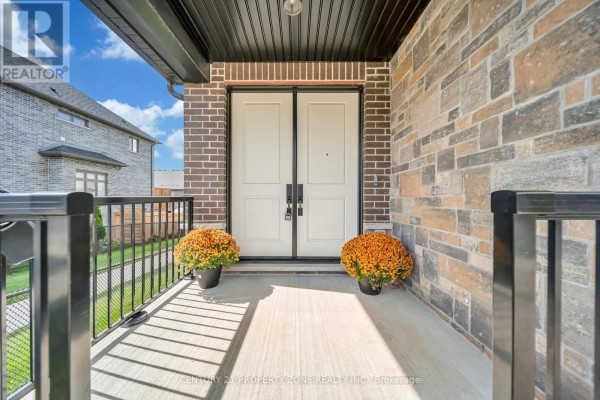 Foyer with grey walls, tiled floor, a gold console table and a small couch. - 187 Forest Creek Drive, Kitchener