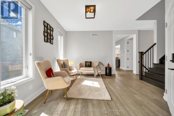 Living area with two armchairs, a sofa, a white rug, and grey walls. - 187 Forest Creek Drive, Kitchener