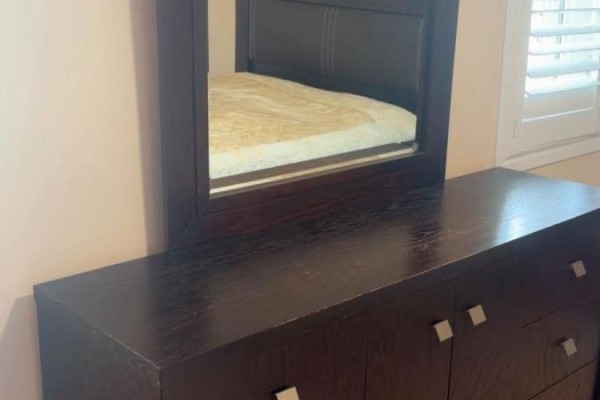 A dark wood dresser with silver hardware and a mirror above it. - 188 Barkley Crescent, Oshawa