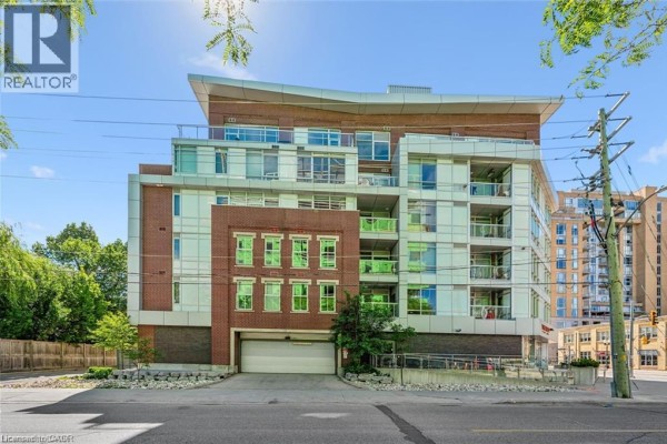 Side exterior view of the building, highlighting the brick facade and glass windows. - 188 King Street S Unit# 304, Waterloo