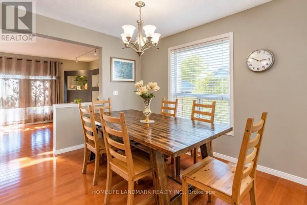 Dining room with a wooden table, six chairs, and a chandelier. - 188 Pineland Court, Waterloo