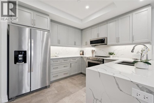 Kitchen view showing stainless steel appliances, white countertops, and gray cabinets. - 1880 Gordon Street Unit# 707, Guelph