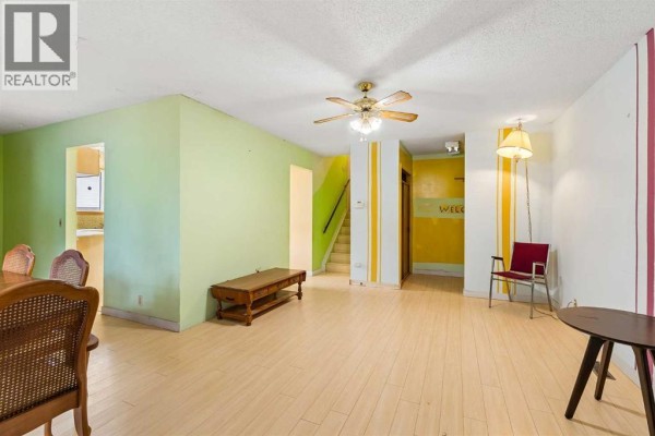 Open-concept living space with lime green and yellow walls, light wood floors. - 189 Whitaker Close Ne, Calgary