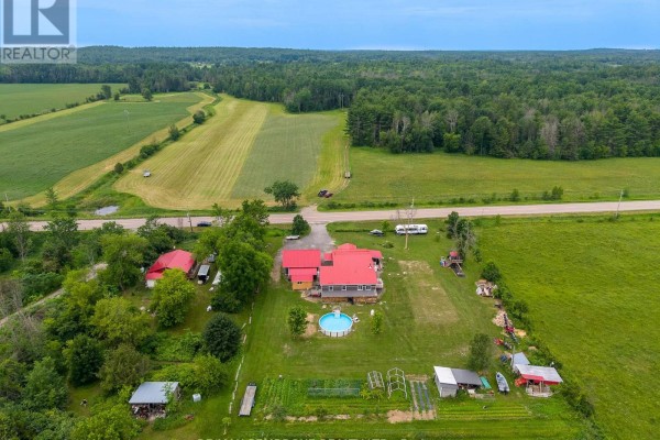 Aerial view of a rural property with fields, trees, a house, garage, and a small pool. - 1890 Queensline Road, Whitewater Region