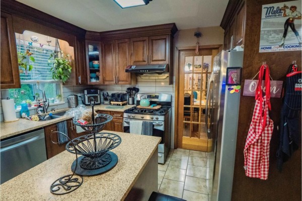 Open-concept kitchen and living area with a breakfast bar, casual dining space, and ambient lighting. - 18961 60b Avenue, Surrey