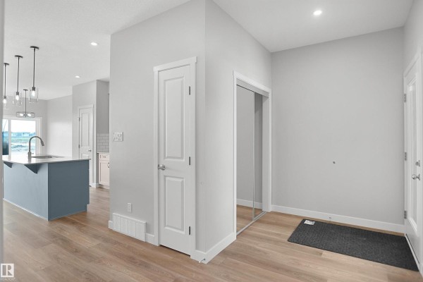 Entryway with mirrored closet and light wood flooring - 18963 28 Av Nw, Edmonton