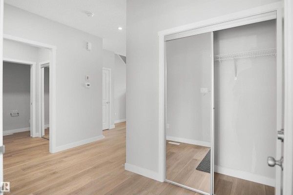 Hallway view with doors leading to rooms and light wood flooring - 18963 28 Av Nw, Edmonton