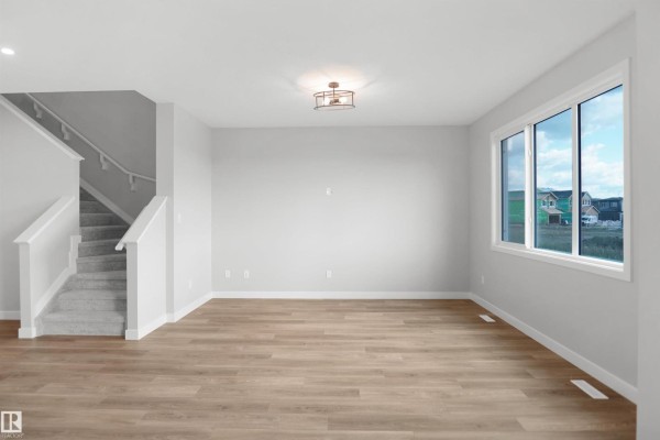 Spacious kitchen with island, modern cabinetry, and open layout to living area - 18963 28 Av Nw, Edmonton