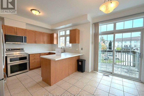 Kitchen with light wood cabinets, stainless steel appliances, white countertops, and tiled floor. - 19 - 10 Post Oak Drive, Richmond Hill