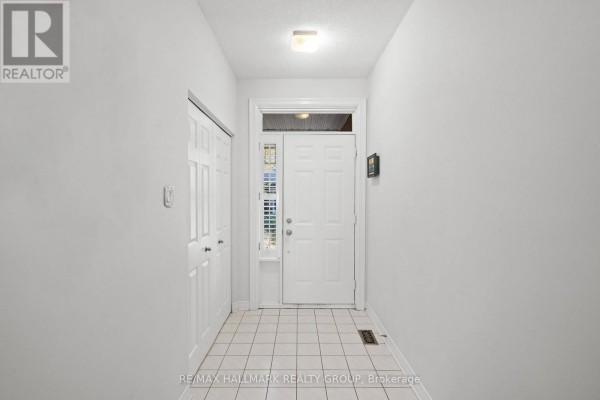 Interior entrance hallway with white tiled floor and a closed double closet. - 19 - 1240 Kilborn Place, Ottawa