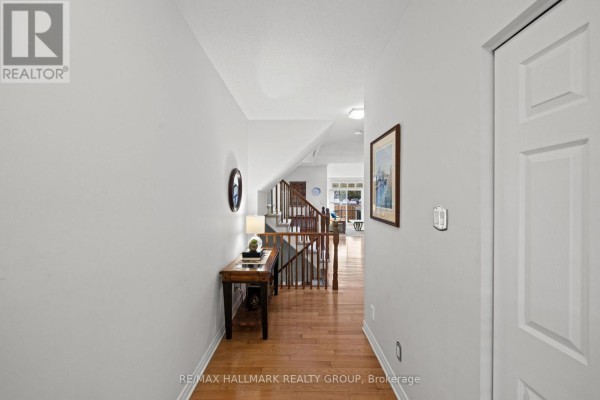 Hallway with hardwood floors, a console table, and a view of the staircase. - 19 - 1240 Kilborn Place, Ottawa