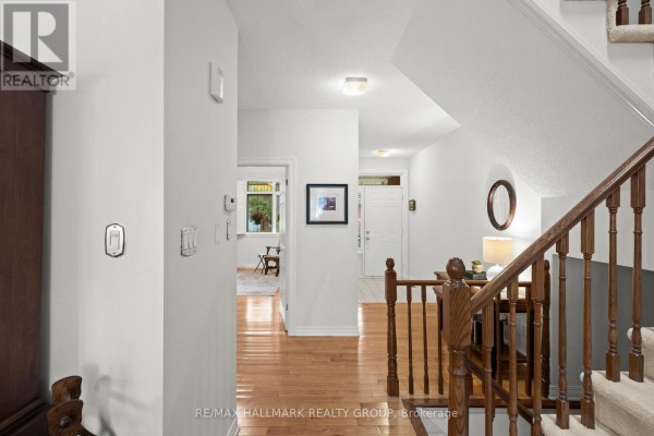 Hallway view looking towards the front entrance and staircase with wooden banister. - 19 - 1240 Kilborn Place, Ottawa
